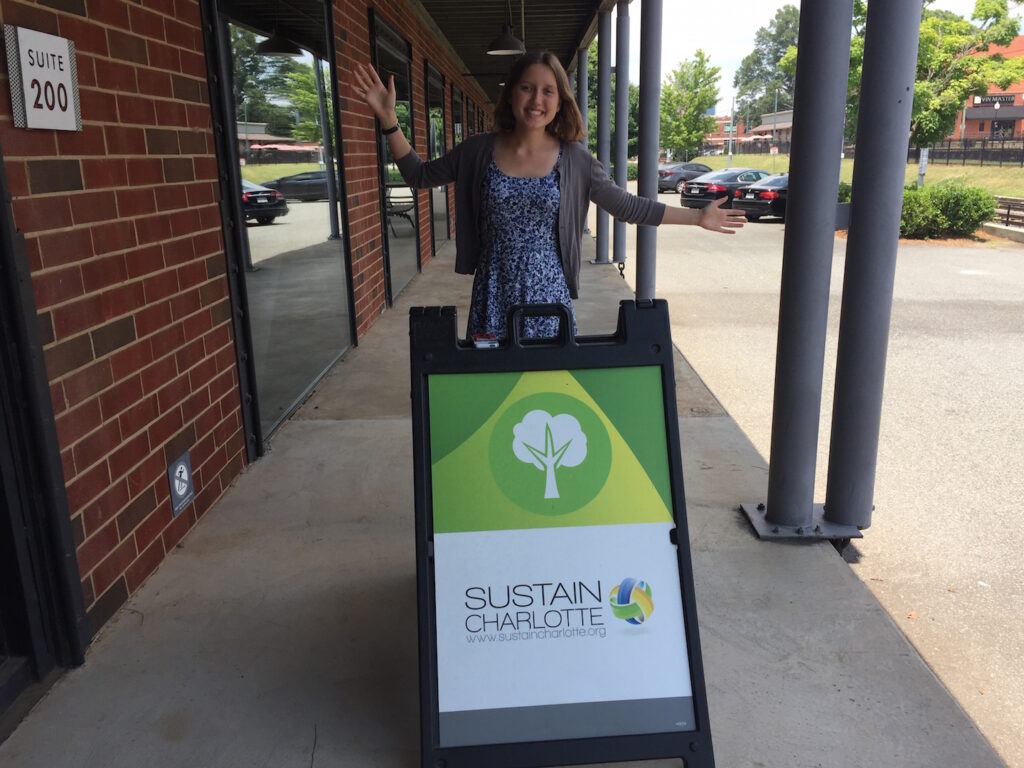 Intern in front of sign