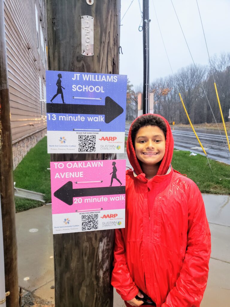 Kid poses in front of walking signs
