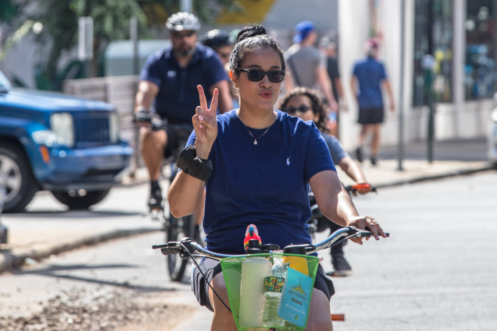 Woman giving peace sign on bike